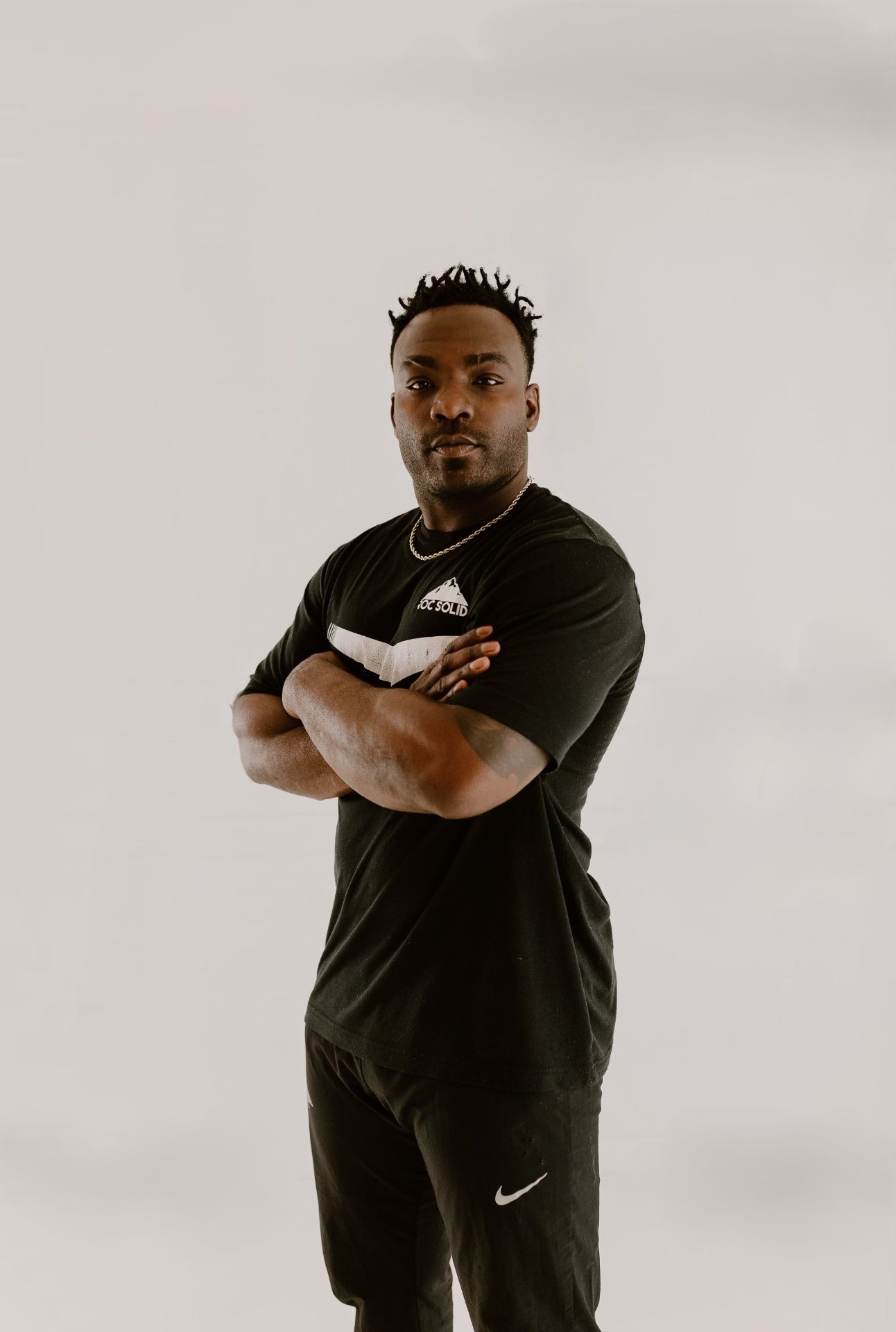 Coach Ben Birmingham standing with arms crossed at the Roc Solid training facility